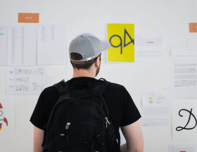 A student checking the whiteboard for schedule and class updates.